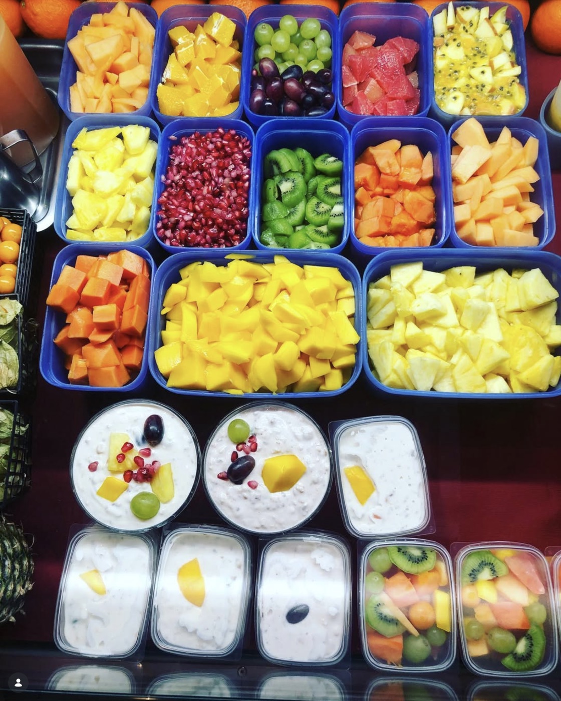 Frische Obstsorten in der Theke: Melone, Mango, Granatapfel, Kiwi und mehr